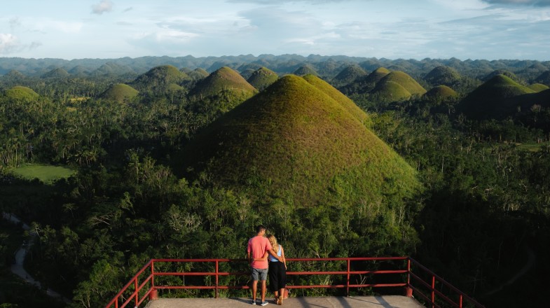 Couple hike and admire the Chocolate Hills; one of the best things to do in the Philippines.