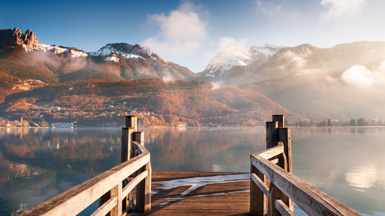 The view of Lake Annecy from a wooden pier and calm water in France in December.