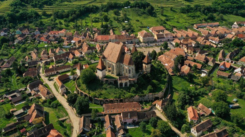 Aerial view of a church surrounded by a village in Transylvania