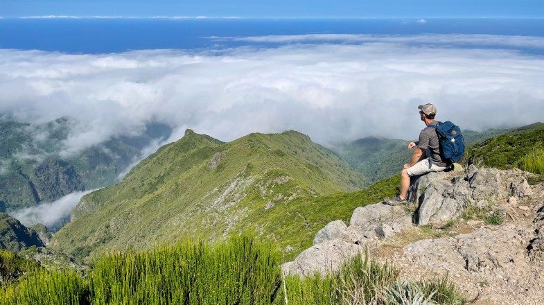 A young hiker sitting & admiring the view from above in Portugal in winter.