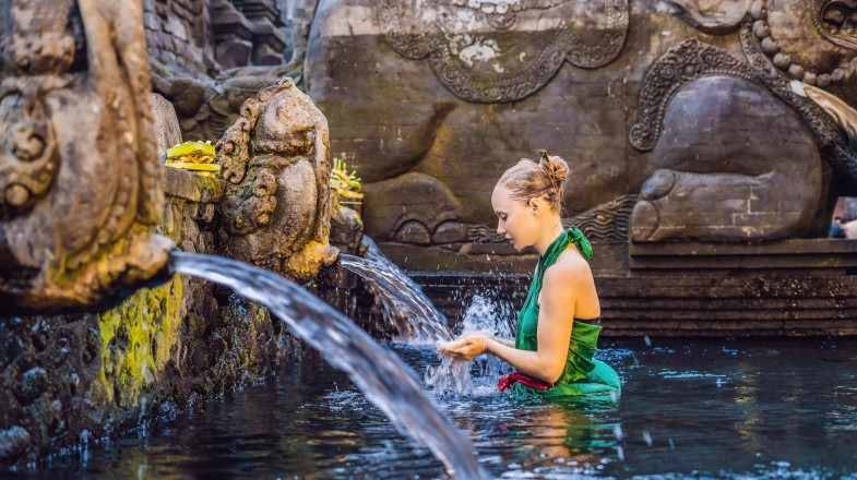Enjoy the experience with the relaxing holy spring water temple in Bali during your visit in Indonesia in December.. Women in the holy spring water temple in Indonesia in December.