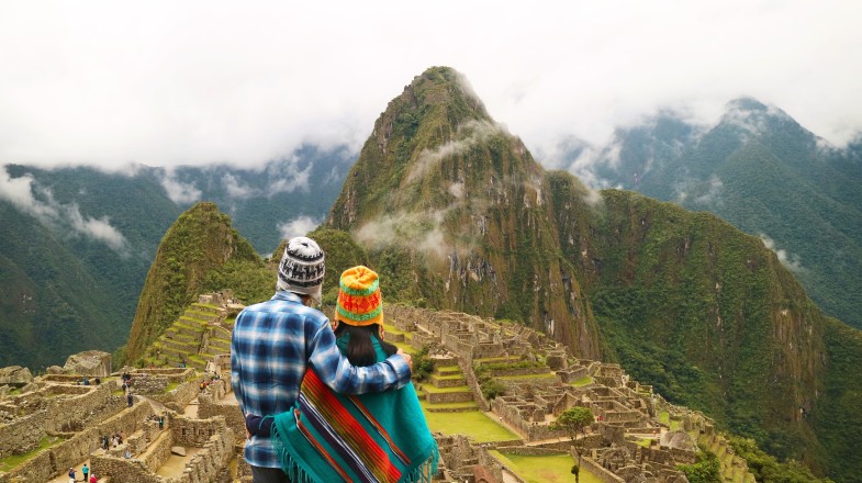 A couple admiring the view of Machu Picchu; how many days to spend in Peru.