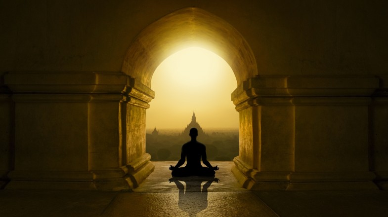 Person meditating inside a Buddhist temple