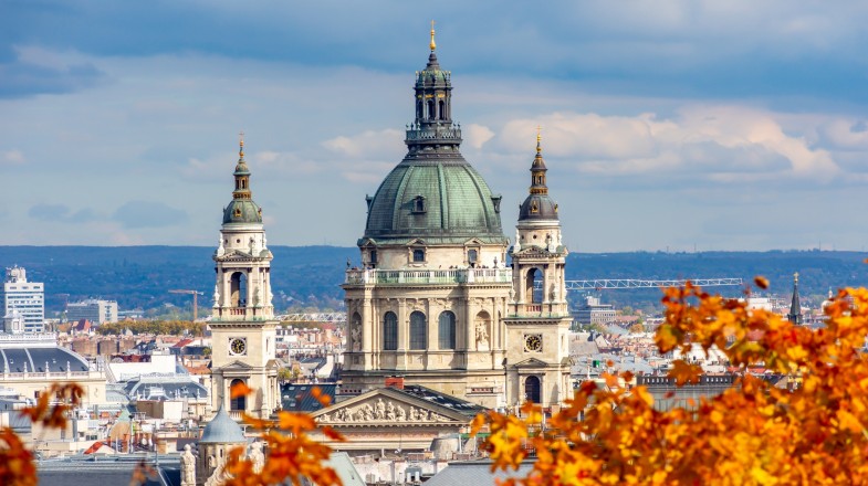 Watch Budapest covered in fall colors in September and enjoy amazing outdoor activities. Fall leaves frame St. Stephen's Basilica in Hungary in September.