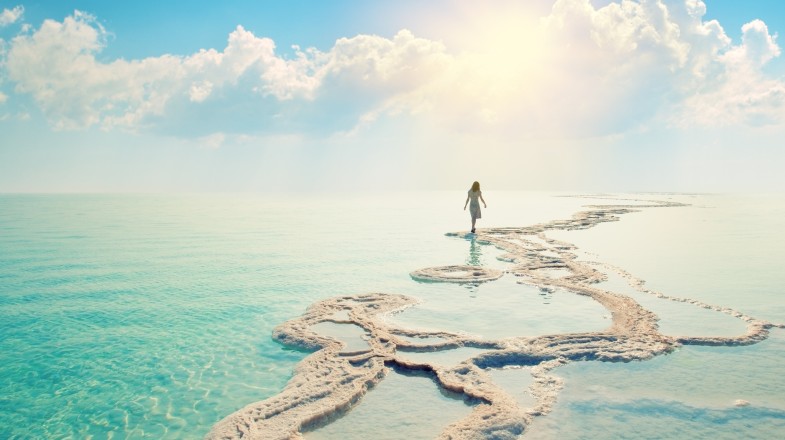 Woman walking on the shore of the Dead Sea in Israel.