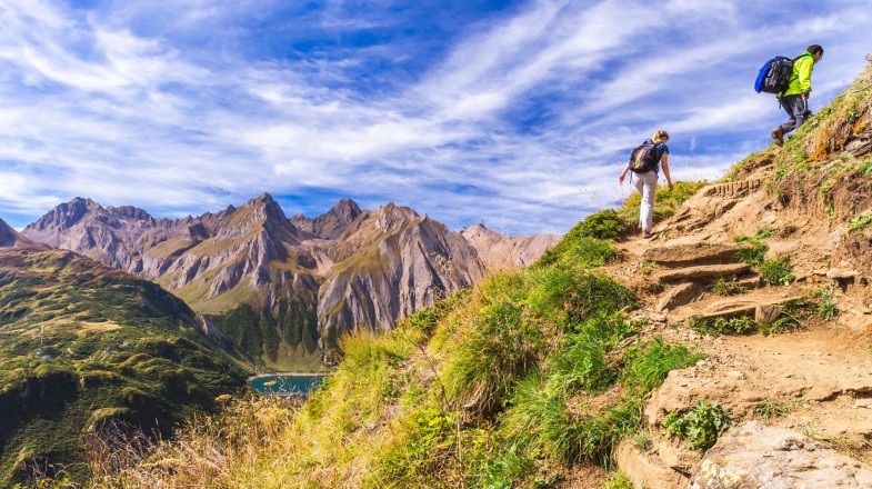 A young couple hiking in the mountains on a sunny day in Piedmont, Italy in April.