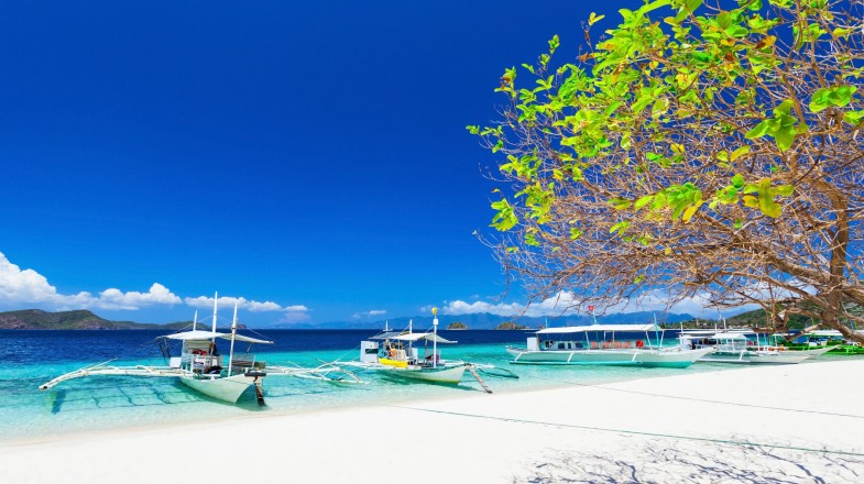 Filipino boats in the sea on a sunny day in the Philippines in April.
