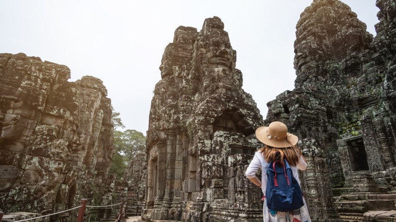 A young woman exploring Angkor Wat, which is one of the best places to visit in Cambodia during dusk.