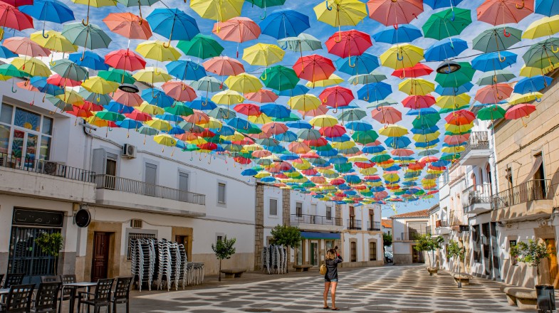 While Portugal in November sees some of the wettest periods in the year, it can make for a lush experience filled with sunshine and festivals. Colourful umbrellas hanging in the sky at the festivities in Portugal in November.