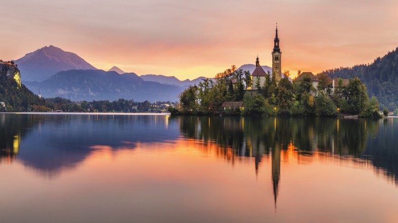 Watch multicolored sunrise over an alpine lake Bled while spending one week in Slovenia.