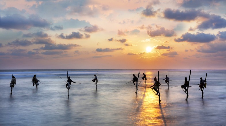 Fishermen on stilts at the sunset in Galle, Sri Lanka in October