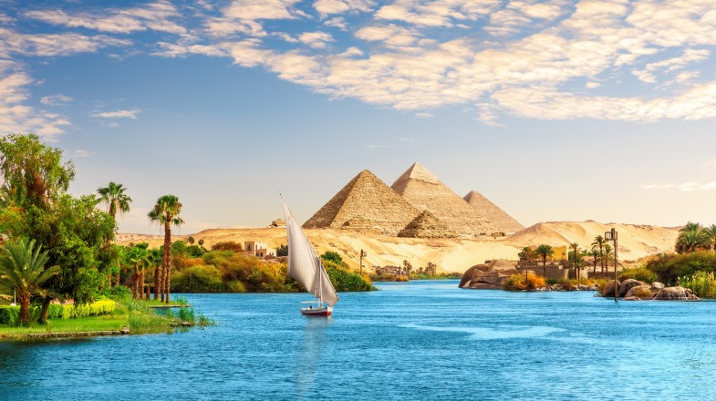 A boat on the Nile in front of pyramids in summer in Egypt.
