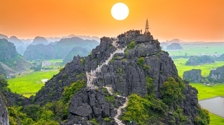 Get this view of the mountains in Tam Coc on your trip to Vietnam in July.