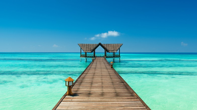 Jetty over the Indian Ocean on a clear day in the Maldives.