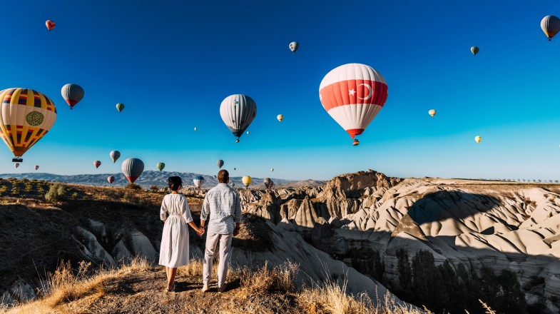 A couple travel influencer enjoying the hot air balloon view.