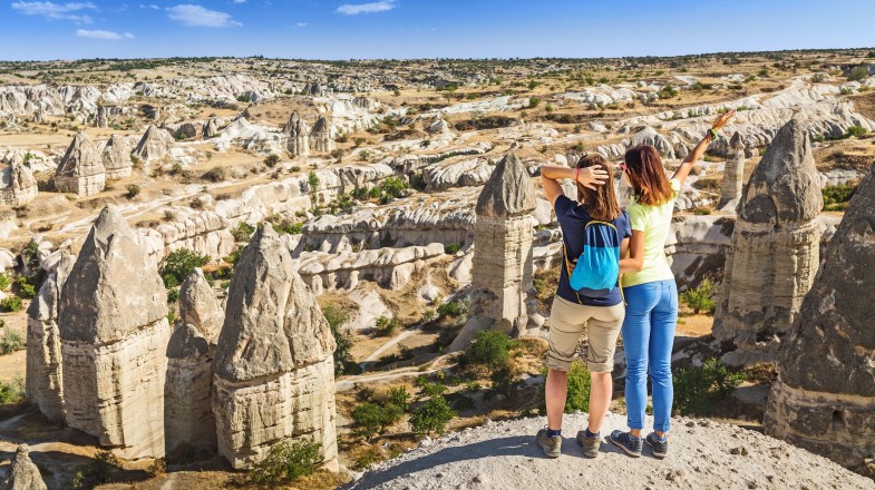 Two tourists enjoy the landscape of Cappadocia on Turkey private tours.